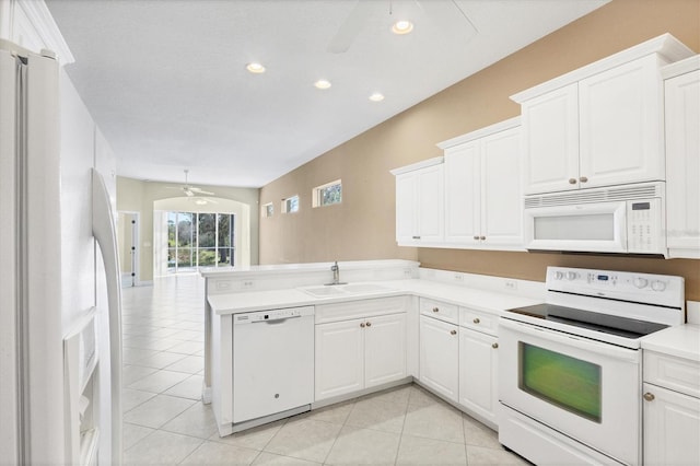 kitchen featuring white appliances, light tile patterned floors, ceiling fan, a peninsula, and a sink