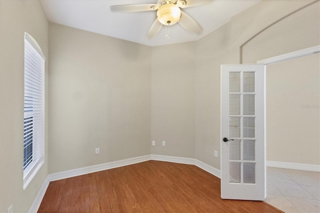 unfurnished room with light wood-type flooring, a healthy amount of sunlight, baseboards, and a ceiling fan