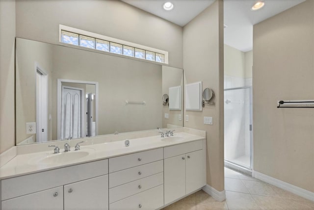 full bath featuring double vanity, a sink, a shower stall, and tile patterned floors