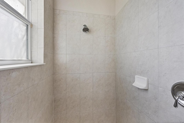 full bathroom featuring tiled shower and a healthy amount of sunlight