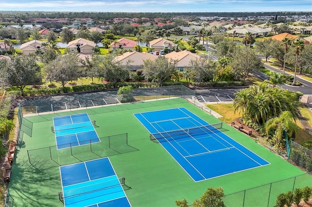 view of tennis court with a residential view and fence