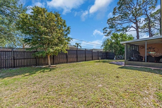 view of yard featuring a fenced backyard and a sunroom