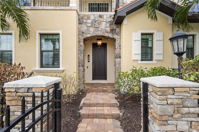 property entrance with stone siding and stucco siding