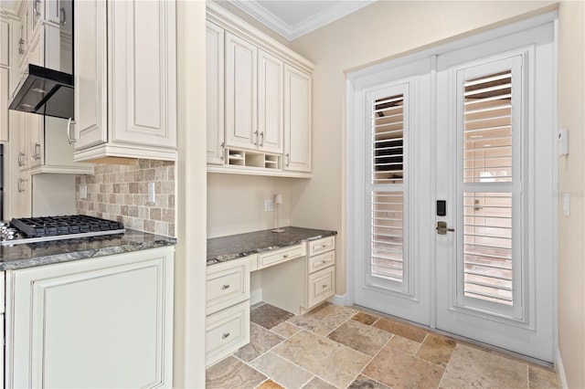 interior space featuring stone tile floors, crown molding, french doors, and built in study area