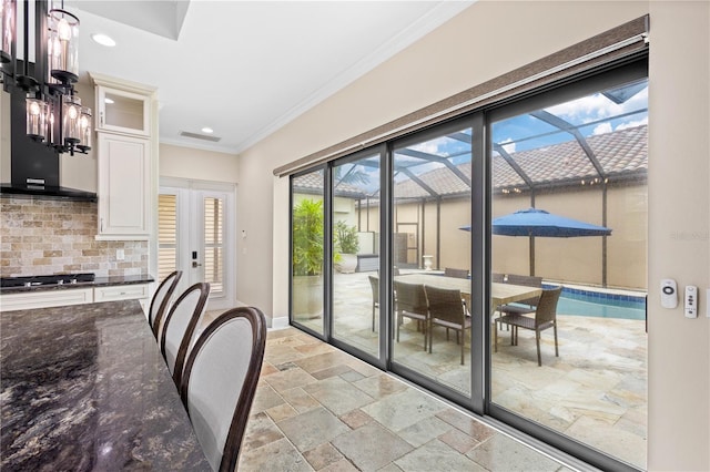 entryway featuring stone tile floors, baseboards, a sunroom, crown molding, and recessed lighting