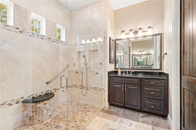 bathroom with a stall shower, stone tile flooring, and vanity