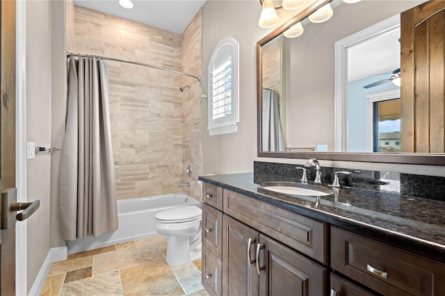 full bathroom with a ceiling fan, toilet, shower / tub combo with curtain, stone tile flooring, and vanity