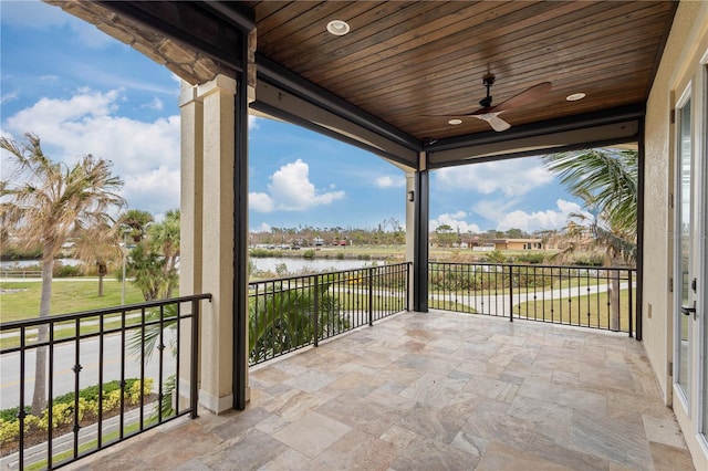 view of patio / terrace with a balcony, a water view, and ceiling fan