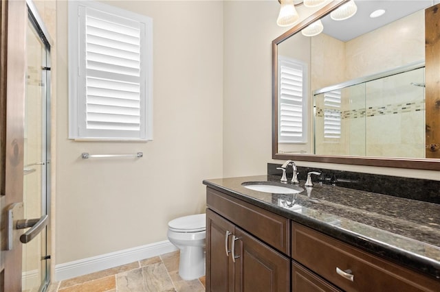 full bathroom with toilet, a shower stall, vanity, and baseboards