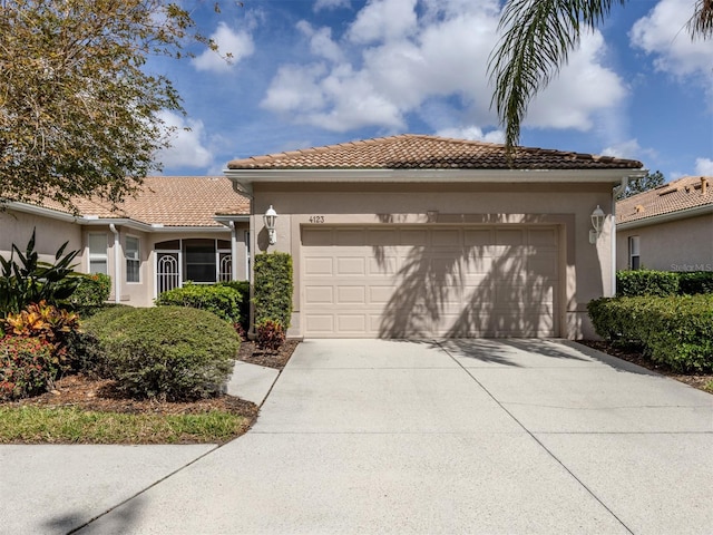 view of front facade with a garage, driveway, a tile roof, and stucco siding