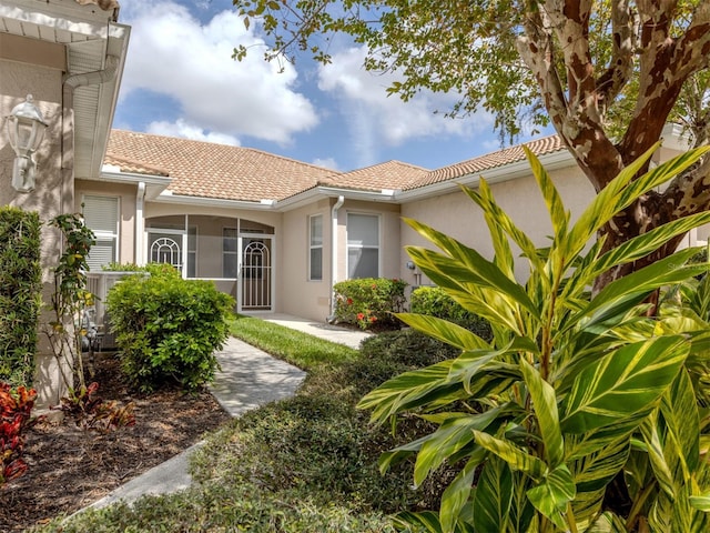 exterior space with a tile roof and stucco siding