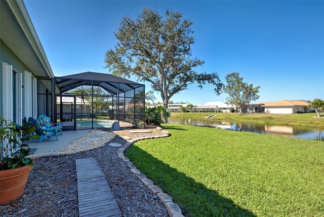 view of yard featuring a patio area, a lanai, and a water view