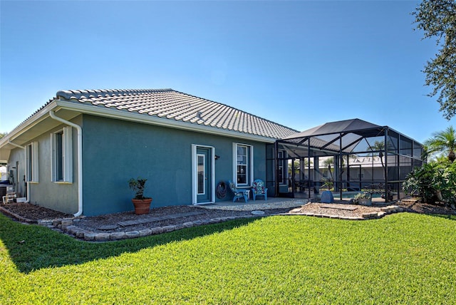 back of property featuring stucco siding, a lawn, a patio area, a lanai, and a tiled roof