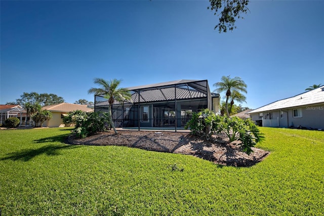 back of property with glass enclosure and a yard