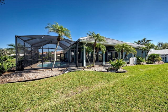 rear view of property featuring a lanai, a tile roof, an outdoor pool, and a lawn