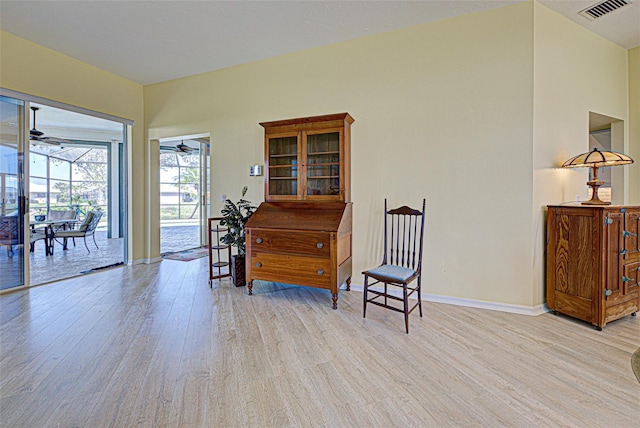 sitting room featuring ceiling fan, wood finished floors, a sunroom, visible vents, and baseboards