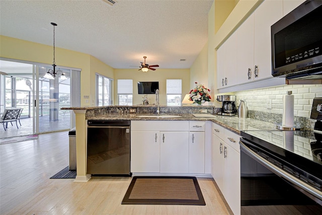 kitchen featuring electric range, dishwasher, stainless steel microwave, a peninsula, and a sink