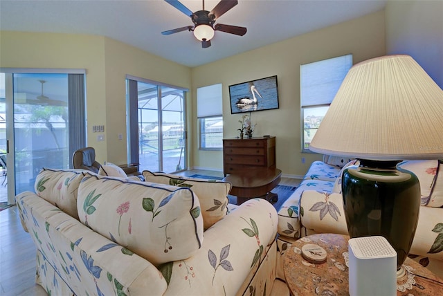 living room featuring ceiling fan, baseboards, and wood finished floors