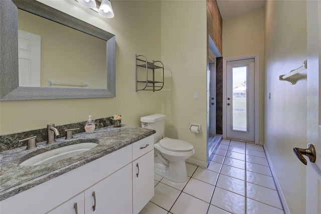 bathroom with baseboards, toilet, tile patterned floors, vanity, and a shower stall