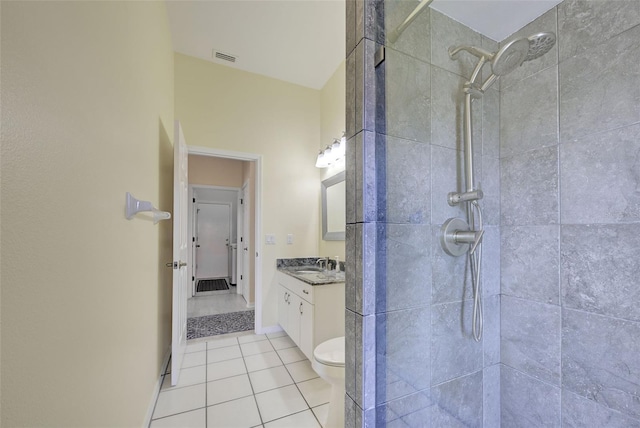 bathroom with visible vents, tiled shower, toilet, tile patterned flooring, and vanity