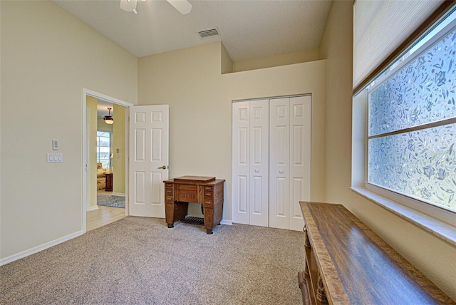 unfurnished bedroom with baseboards, visible vents, ceiling fan, carpet flooring, and a closet