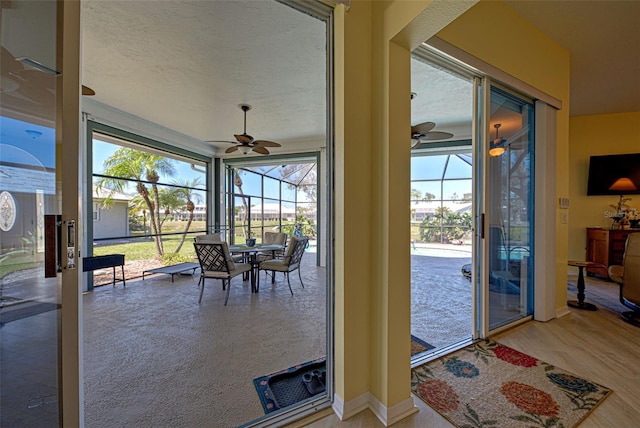 sunroom / solarium featuring a ceiling fan and a wealth of natural light