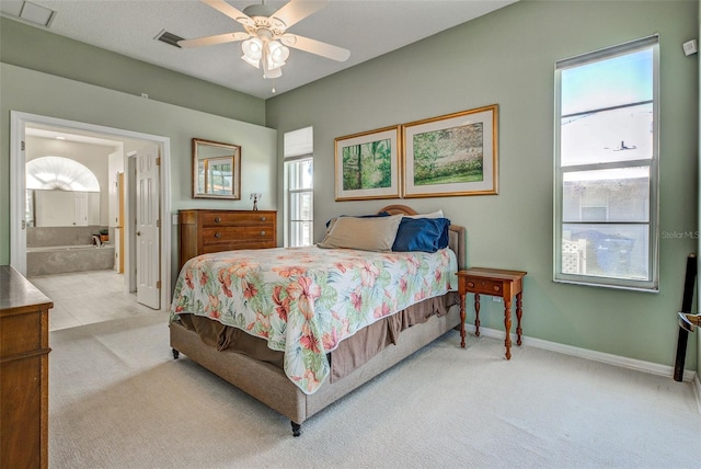 carpeted bedroom featuring visible vents, ceiling fan, baseboards, and ensuite bathroom