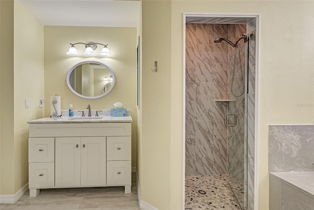 full bath featuring a shower stall, vanity, and baseboards