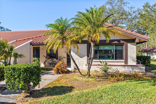 view of front of home with a tiled roof and stucco siding