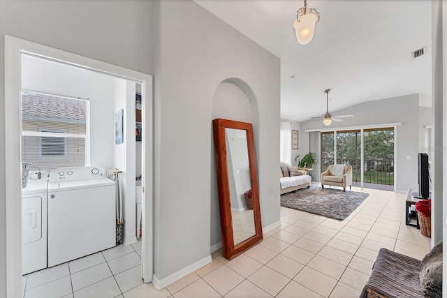 interior space with visible vents, a ceiling fan, washer and clothes dryer, light tile patterned floors, and lofted ceiling