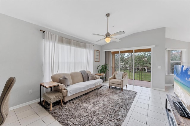 living area featuring vaulted ceiling, light tile patterned flooring, baseboards, and ceiling fan