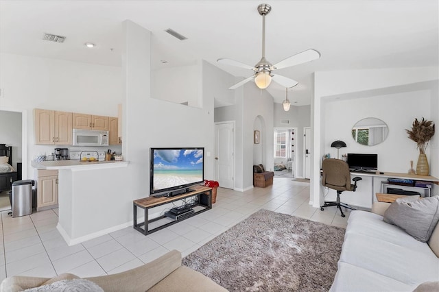 living room with light tile patterned floors, visible vents, high vaulted ceiling, and ceiling fan