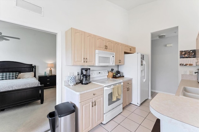 kitchen featuring white appliances, light tile patterned floors, visible vents, light brown cabinetry, and light countertops