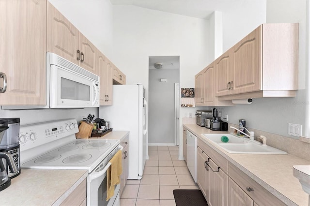 kitchen with white appliances, light brown cabinetry, and light countertops