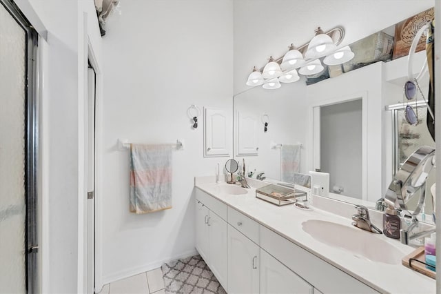 bathroom featuring tile patterned flooring, a shower stall, baseboards, double vanity, and a sink