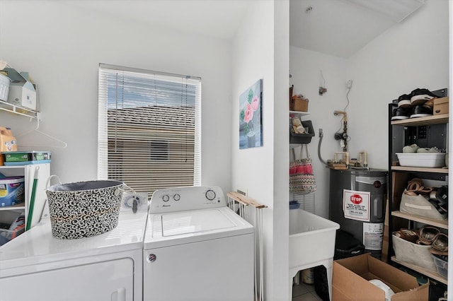 laundry room with washer and dryer, laundry area, water heater, and a sink