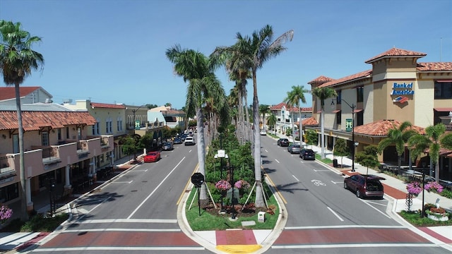 view of road featuring sidewalks, a residential view, curbs, and street lights