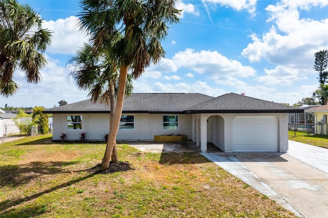 ranch-style house with stucco siding, concrete driveway, a garage, and a front yard