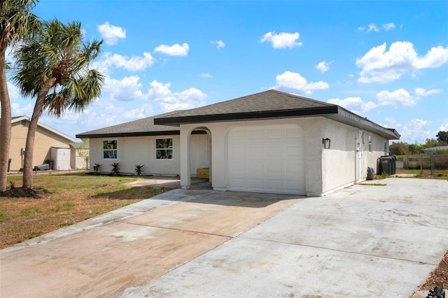 ranch-style house featuring stucco siding, driveway, fence, roof with shingles, and an attached garage