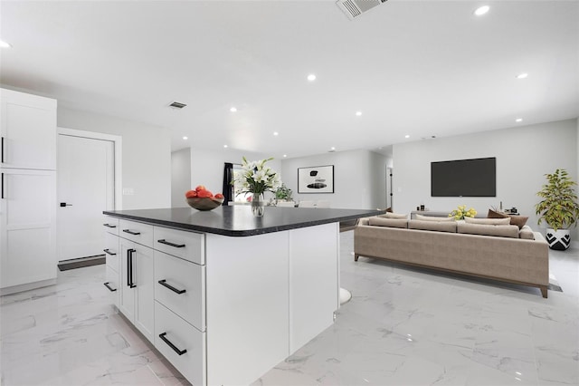 kitchen featuring dark countertops, visible vents, recessed lighting, and marble finish floor