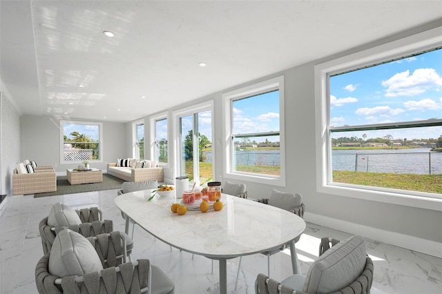 sunroom / solarium featuring a wealth of natural light and a water view