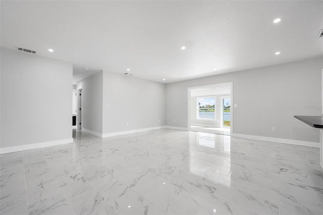 unfurnished living room with recessed lighting, visible vents, baseboards, and marble finish floor