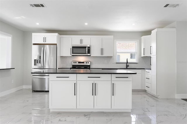 kitchen with visible vents, a sink, decorative backsplash, appliances with stainless steel finishes, and marble finish floor