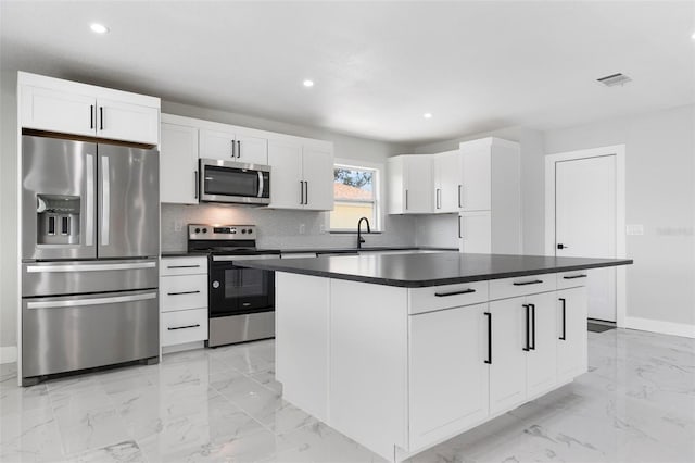 kitchen with visible vents, marble finish floor, dark countertops, appliances with stainless steel finishes, and decorative backsplash