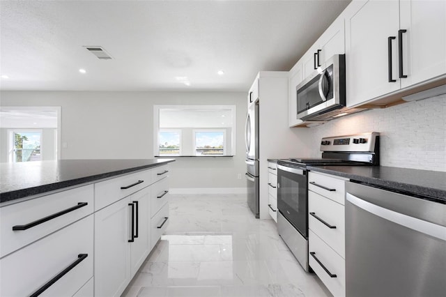 kitchen featuring visible vents, marble finish floor, appliances with stainless steel finishes, dark countertops, and tasteful backsplash