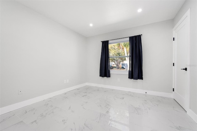 empty room with recessed lighting, baseboards, and marble finish floor