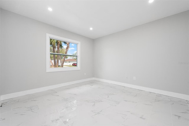 spare room featuring recessed lighting, baseboards, and marble finish floor