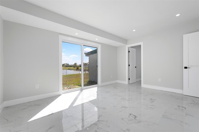 empty room with recessed lighting, baseboards, marble finish floor, and a water view