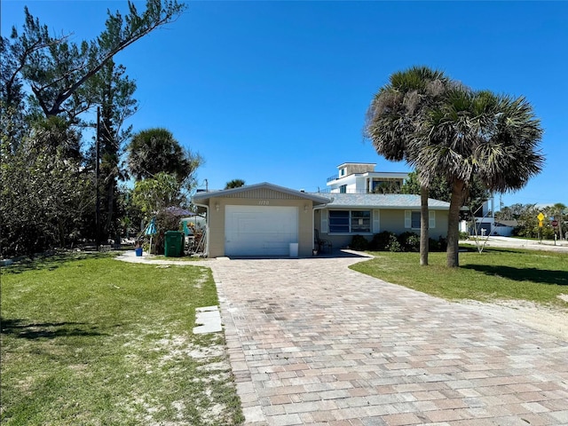 view of front of house with a front lawn, decorative driveway, and an attached garage