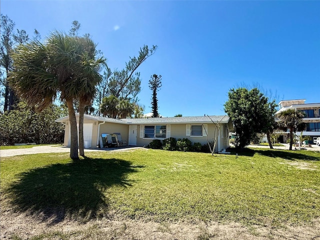 single story home featuring driveway, an attached garage, and a front lawn